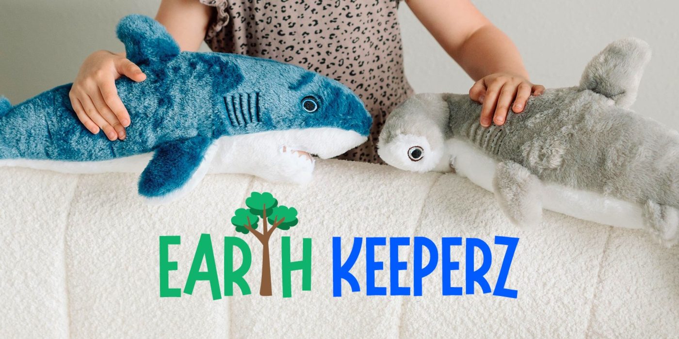 An Earth Keeperz banner showing a child lying beside a shark plush toy