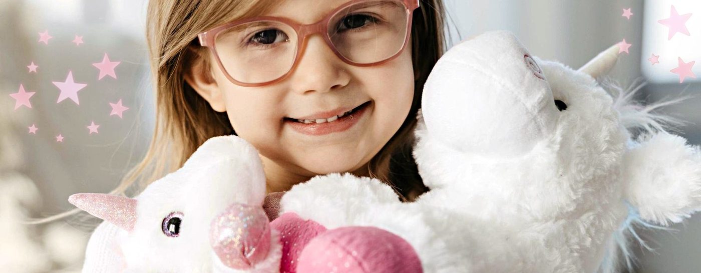 A girl holding a soft white plush toy against a sparkling background