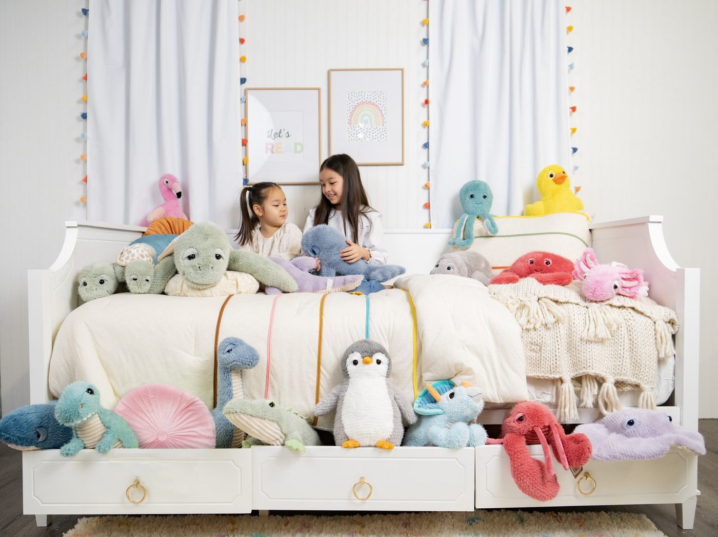 A long shelf of Zoologee plush animals along a child's bedroom wall