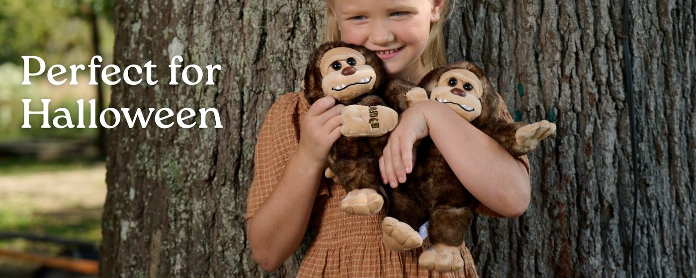 A sloth plush toy hanging from a tree branch